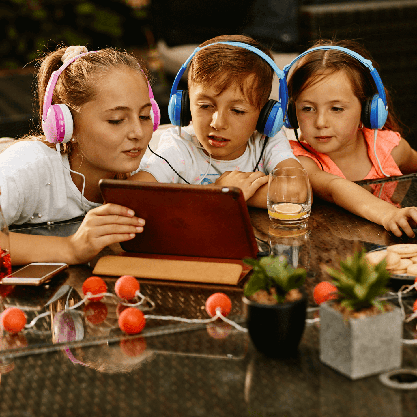children viewing tablet using wireless headphones with sharing audio adapter