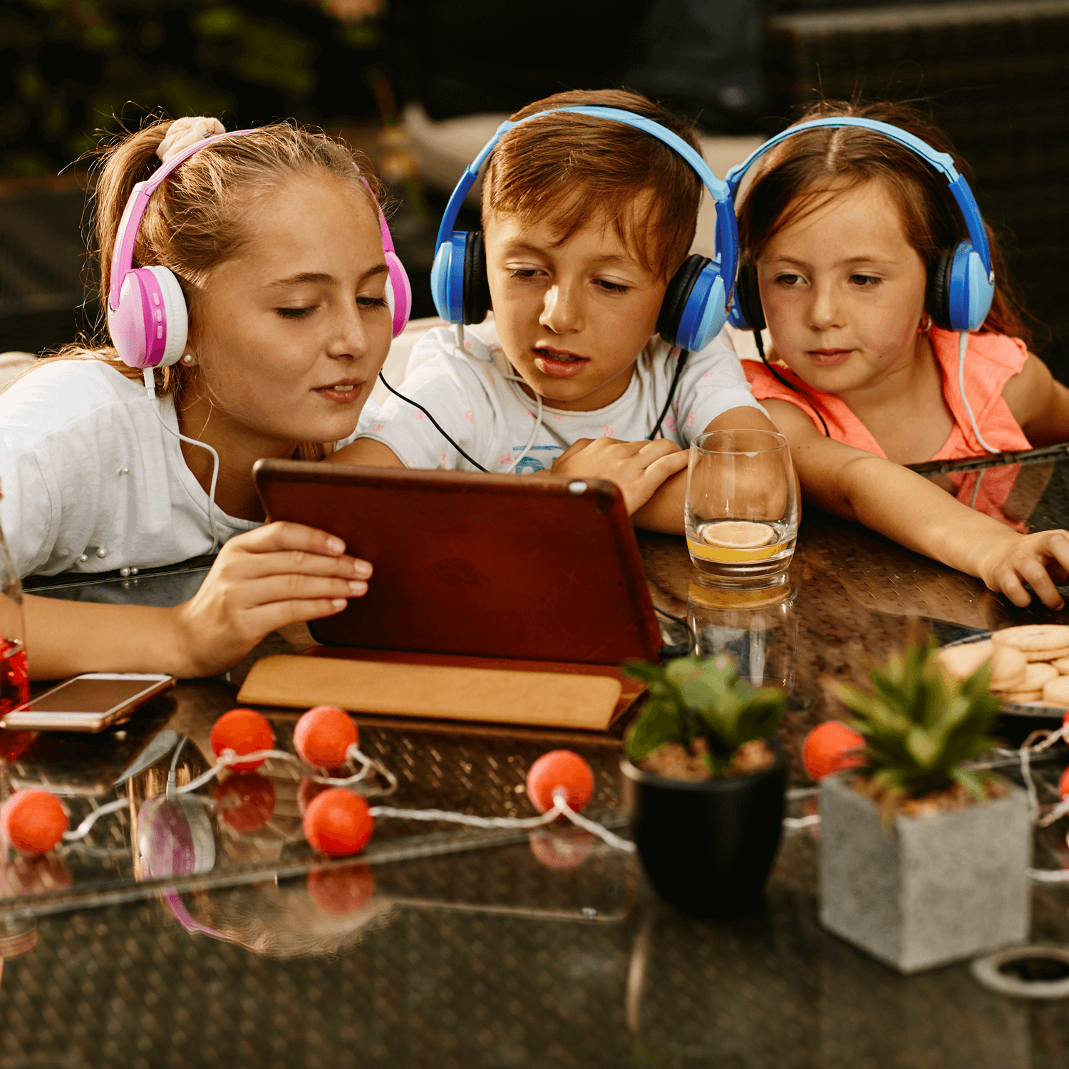 children viewing tablet using wireless headphones with sharing audio adapter